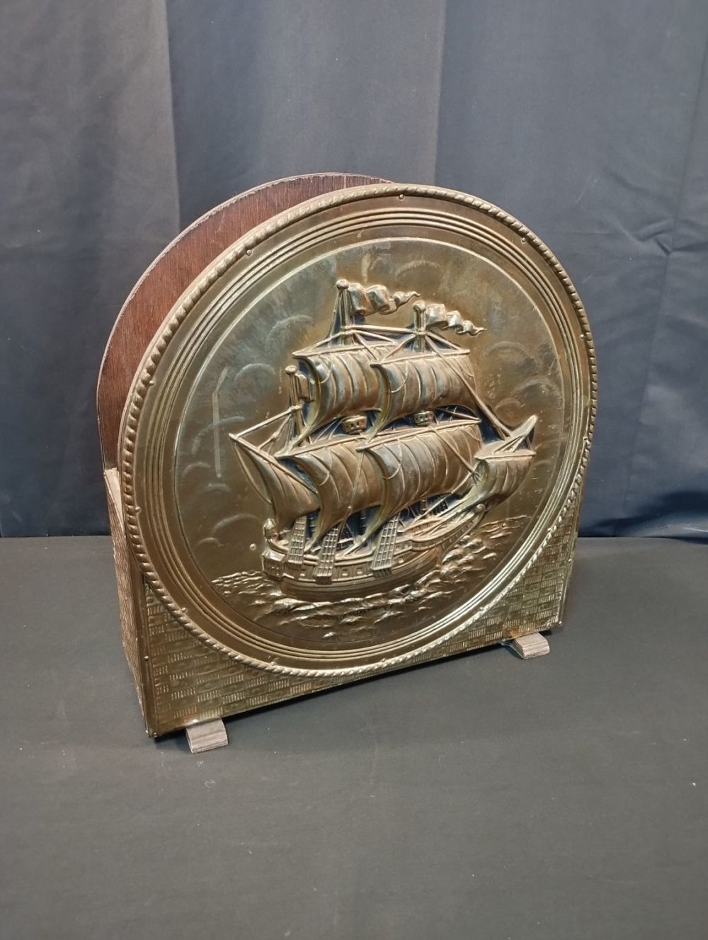 Lot 260: Vintage Magazine Rack with Brass Ship Emblem.