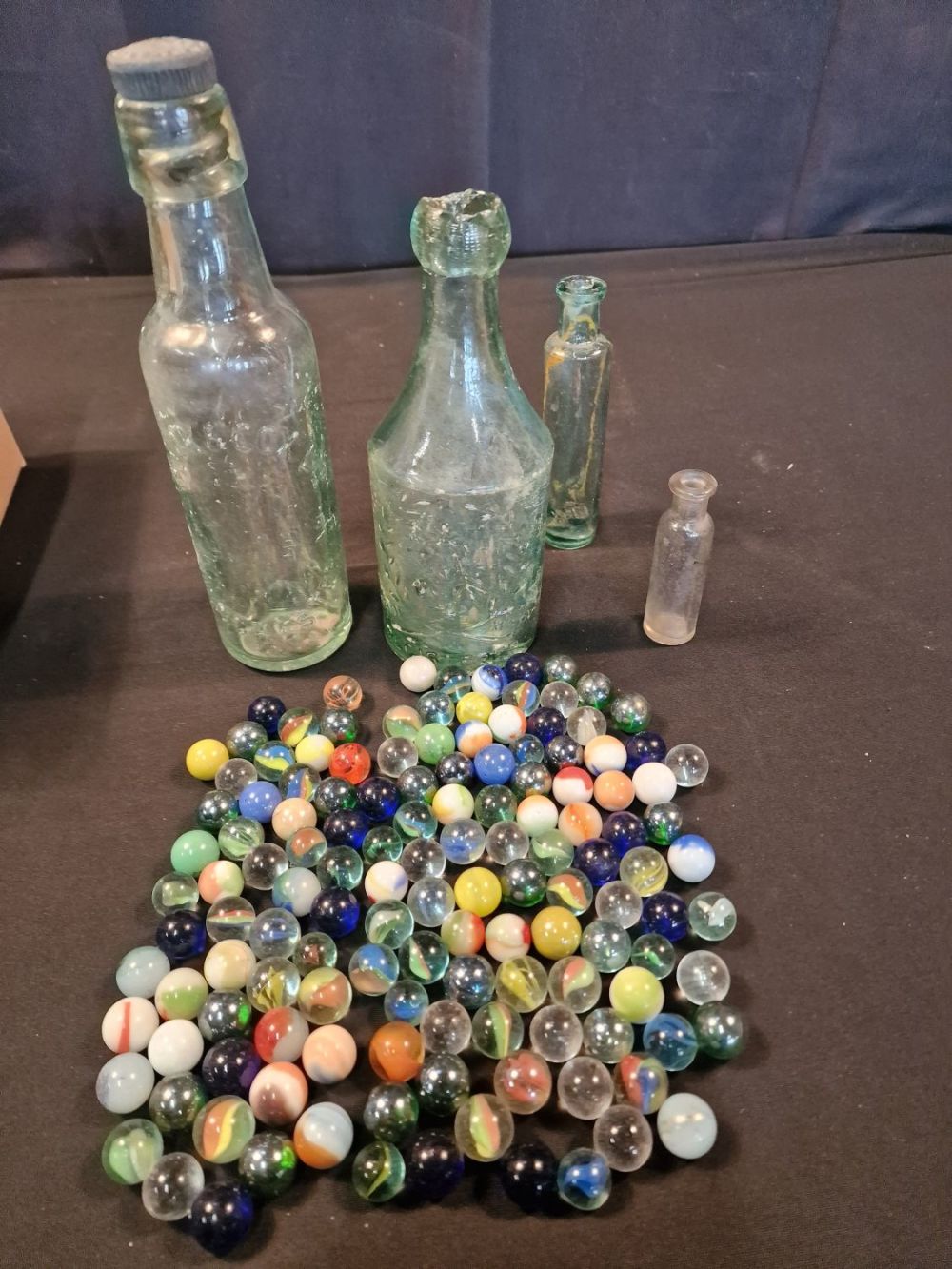 Lot 165: A collection of glass vintage marbles and bottles