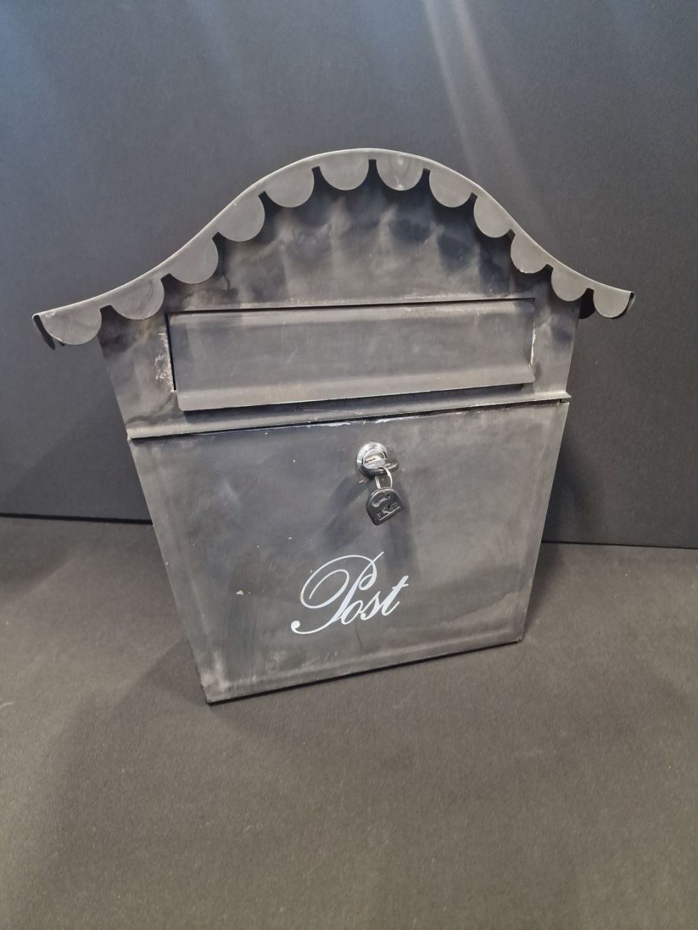 Lot 203: A black metal wall mountable post box.