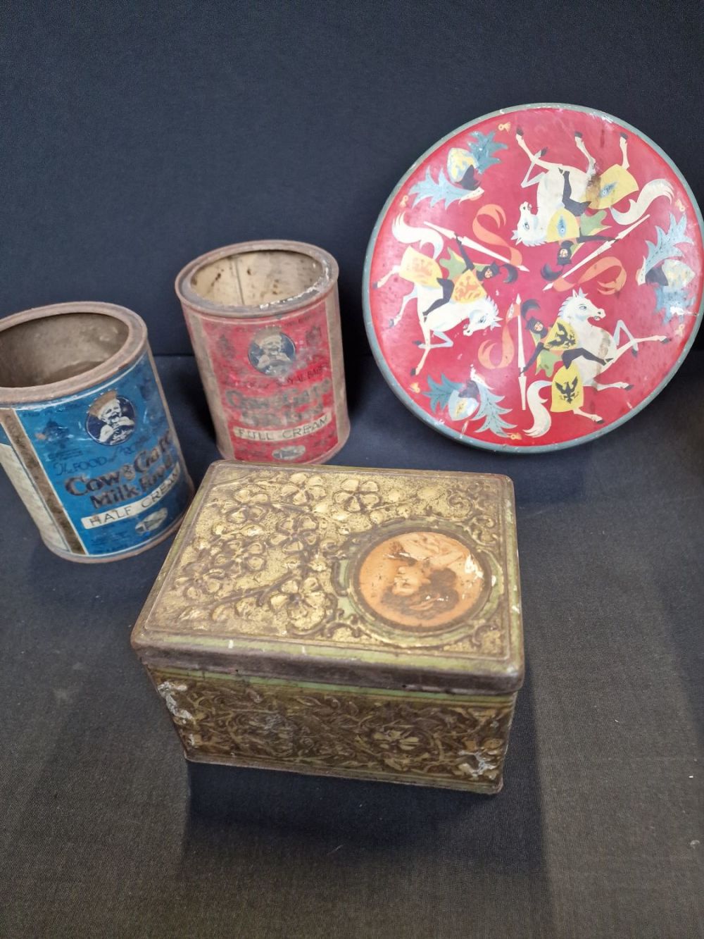 Lot 329: Selection of vintage tins includes Cadbury, cow &...