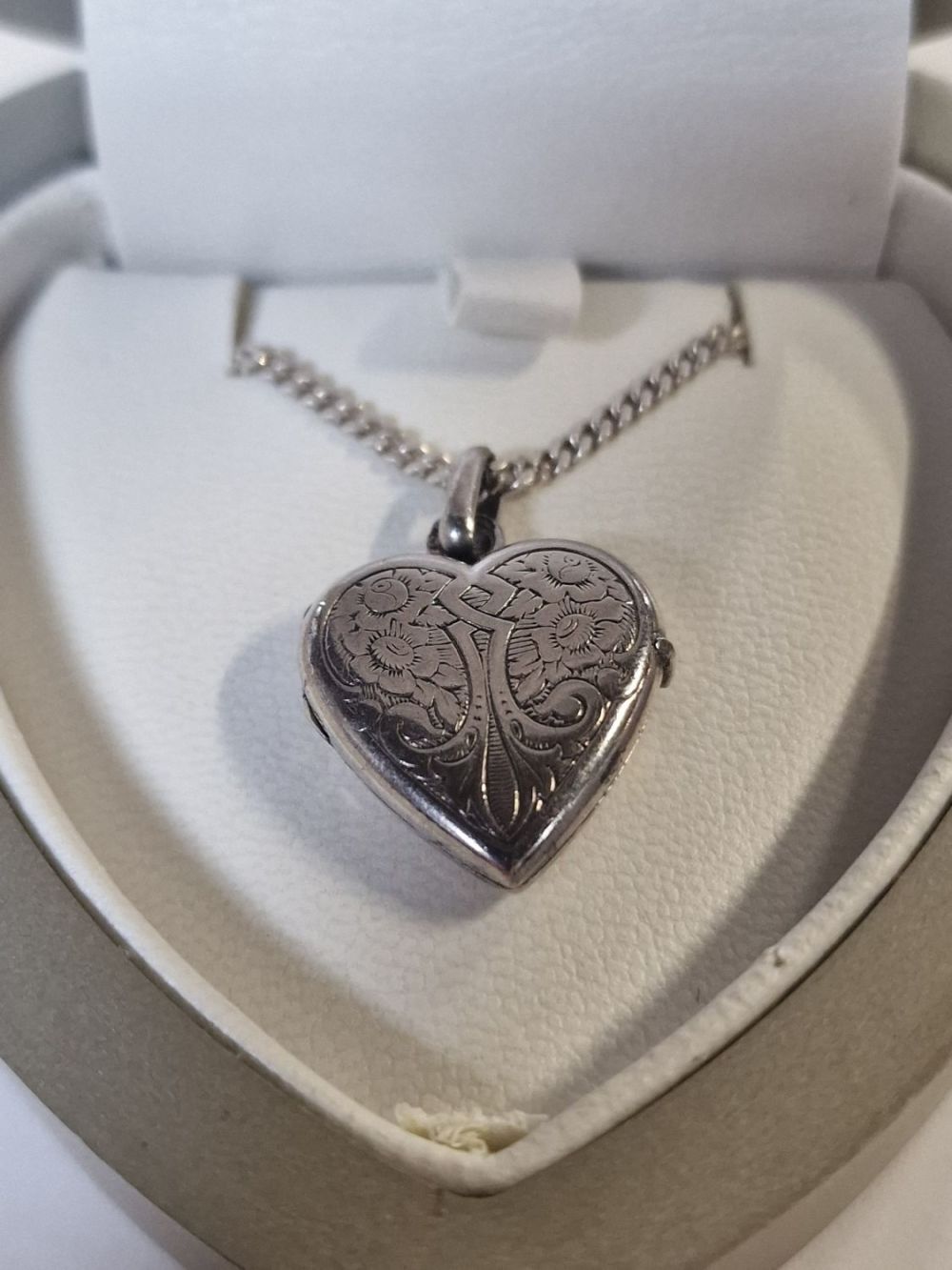 Lot 418: Sterling silver heart locket pendant and chain.