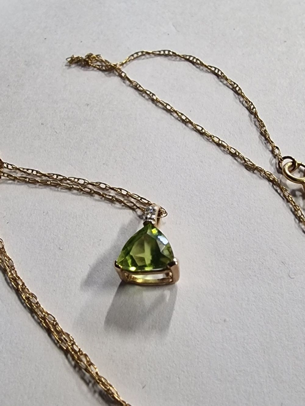 Lot 423: 9ct gold chain with a green peridot stone