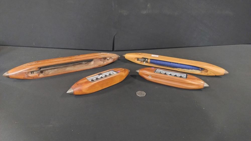 Lot 182: Four wooden shuttles, one has blue thread attached,...