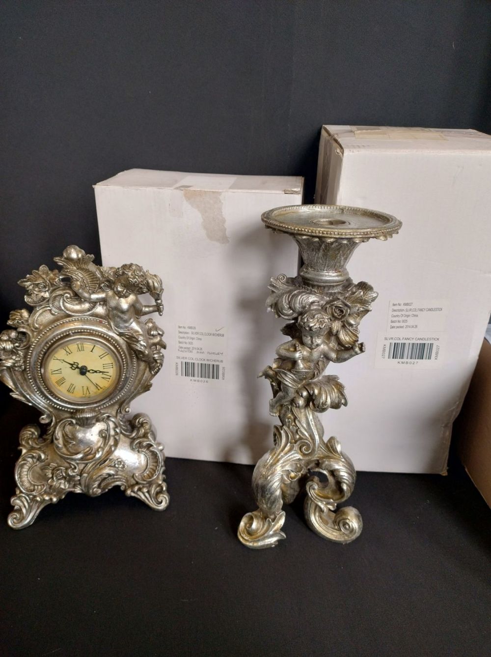 Lot 220: Silver coloured Quatz clock adorned with a cherub...