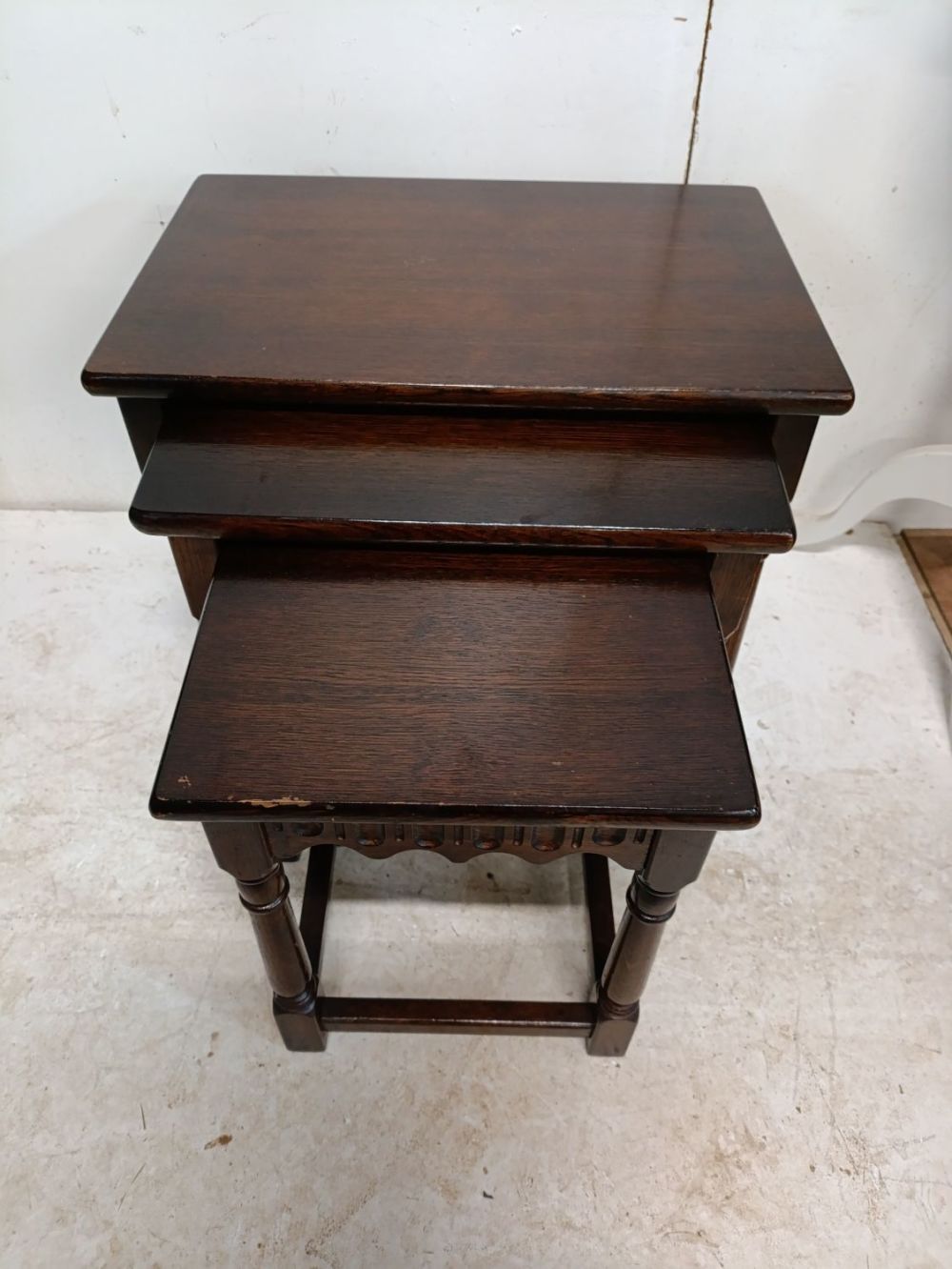 Lot 384: Vintage nest of dark wood tables.