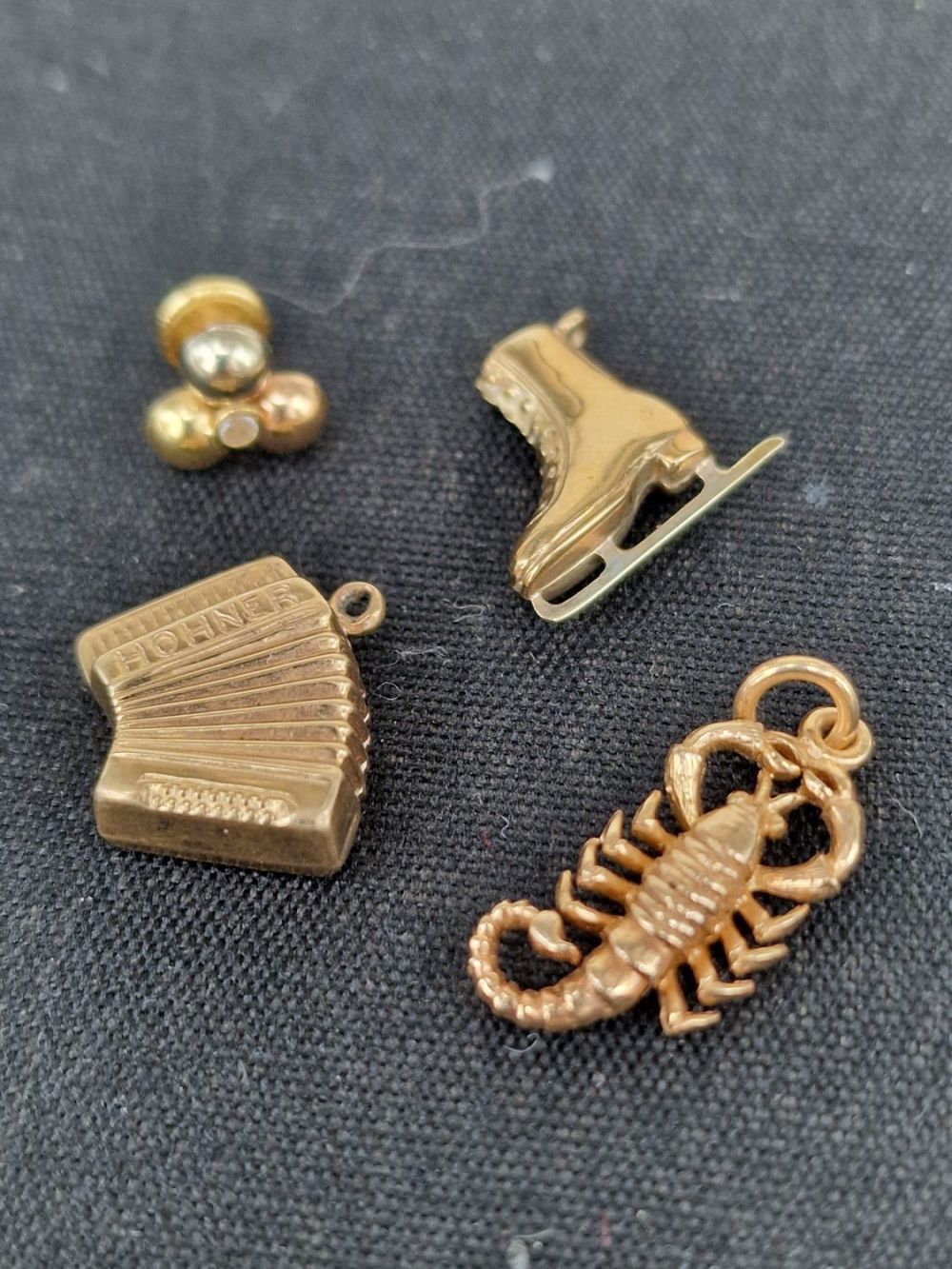 Lot 411: Three 9ct yellow gold pendant / charms, a...