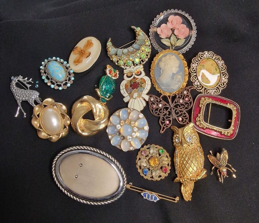 Lot 414: A selection of vintage brooches and lapel clips