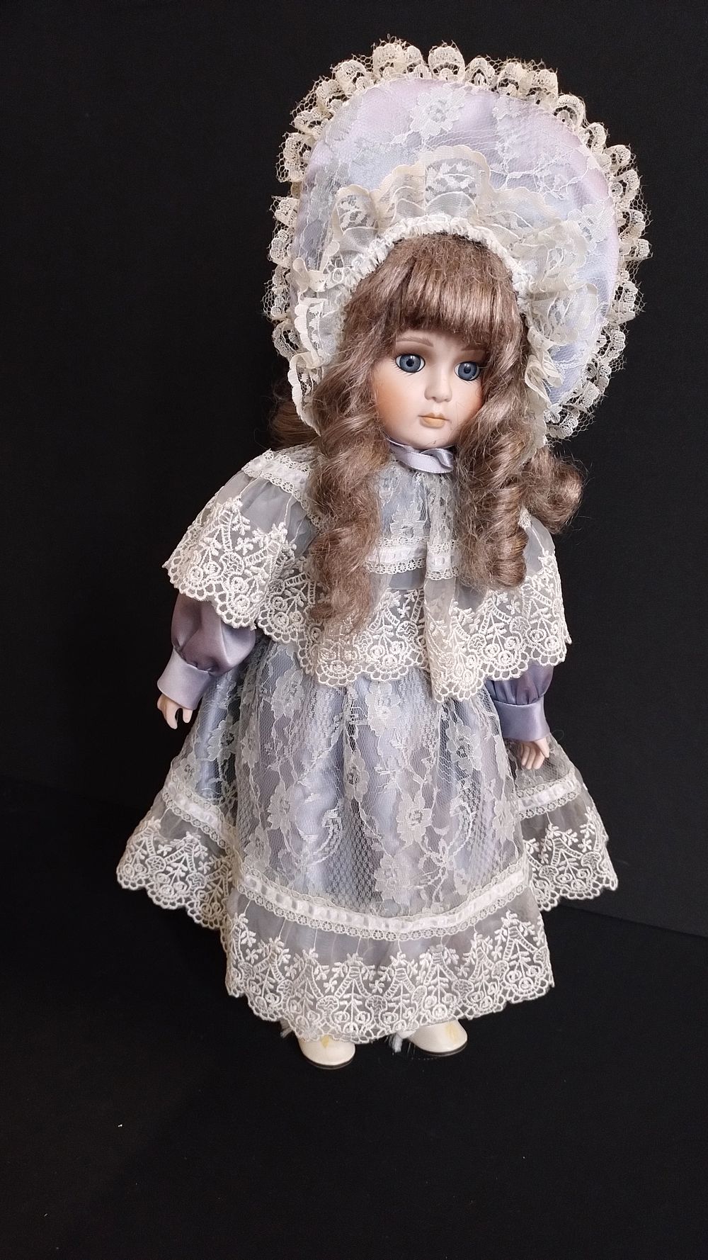 Lot 412: Porcelain doll on a stand in lilac and...