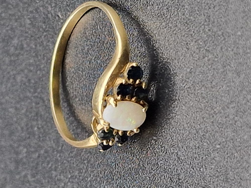 Lot 486: Ladies dress opal ring with black garnet. Weight...