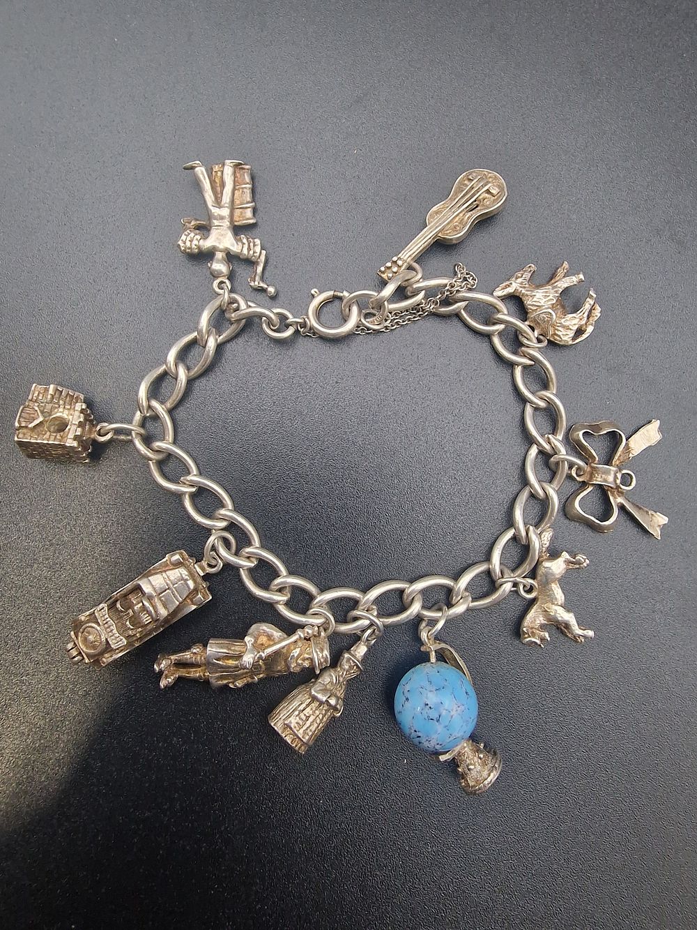 Lot 214: A vintage sterlingnsilver charm bracelet with 10 sterling...