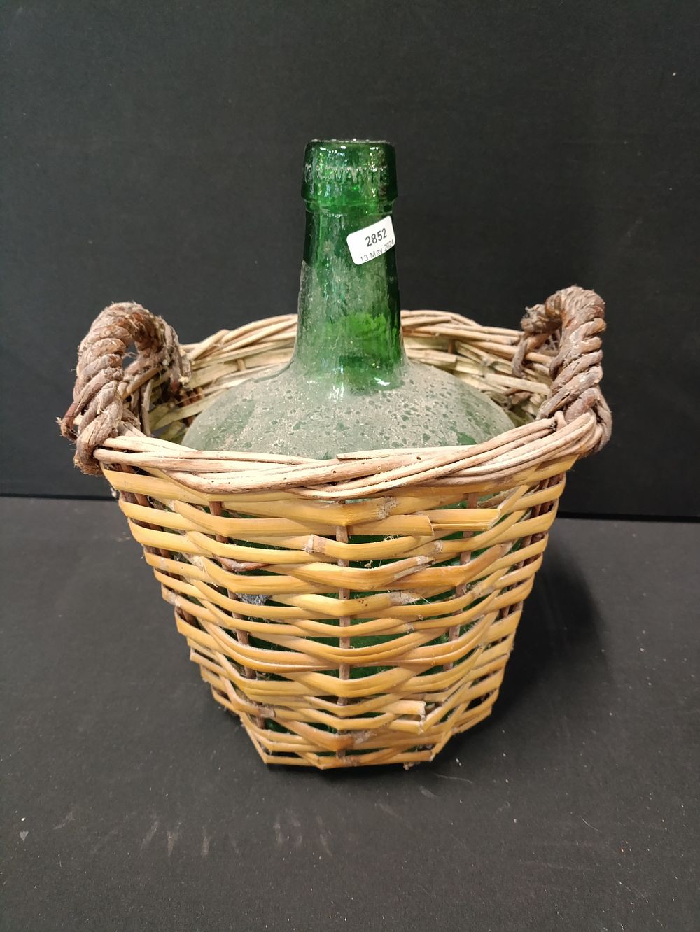 Lot 429: Green demijohn bottle in basket approximately 31cm tall
