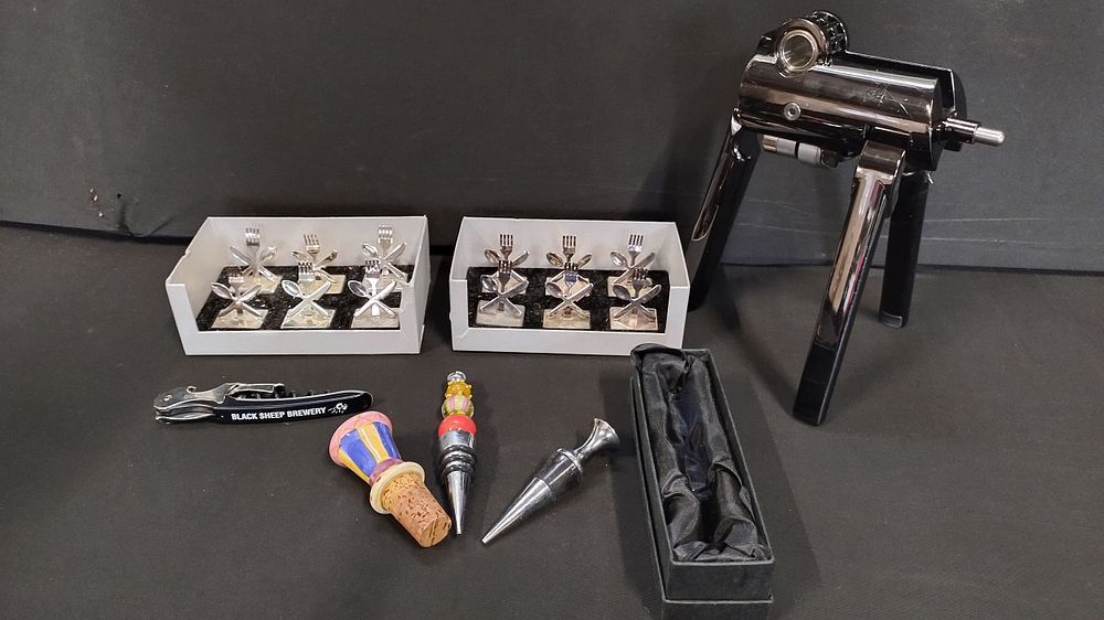 Lot 156: Table place markers, corkscrew and bottle toppers including...