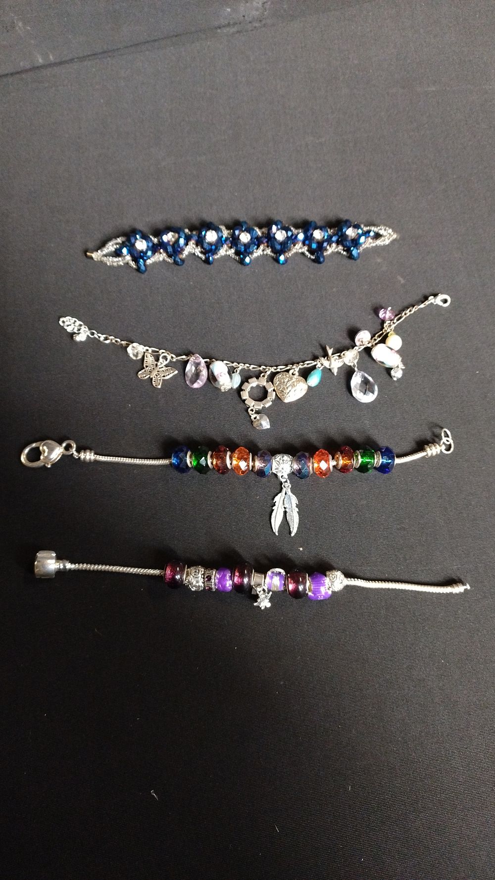 Lot 421: 4 bracelets, 2 with bead charms, one magnetic...