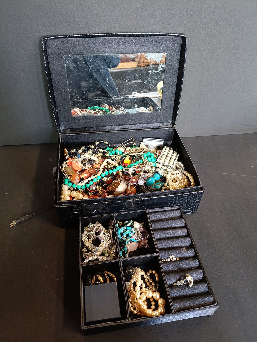 Lot 243: Black Jewellery box with a large selection of...