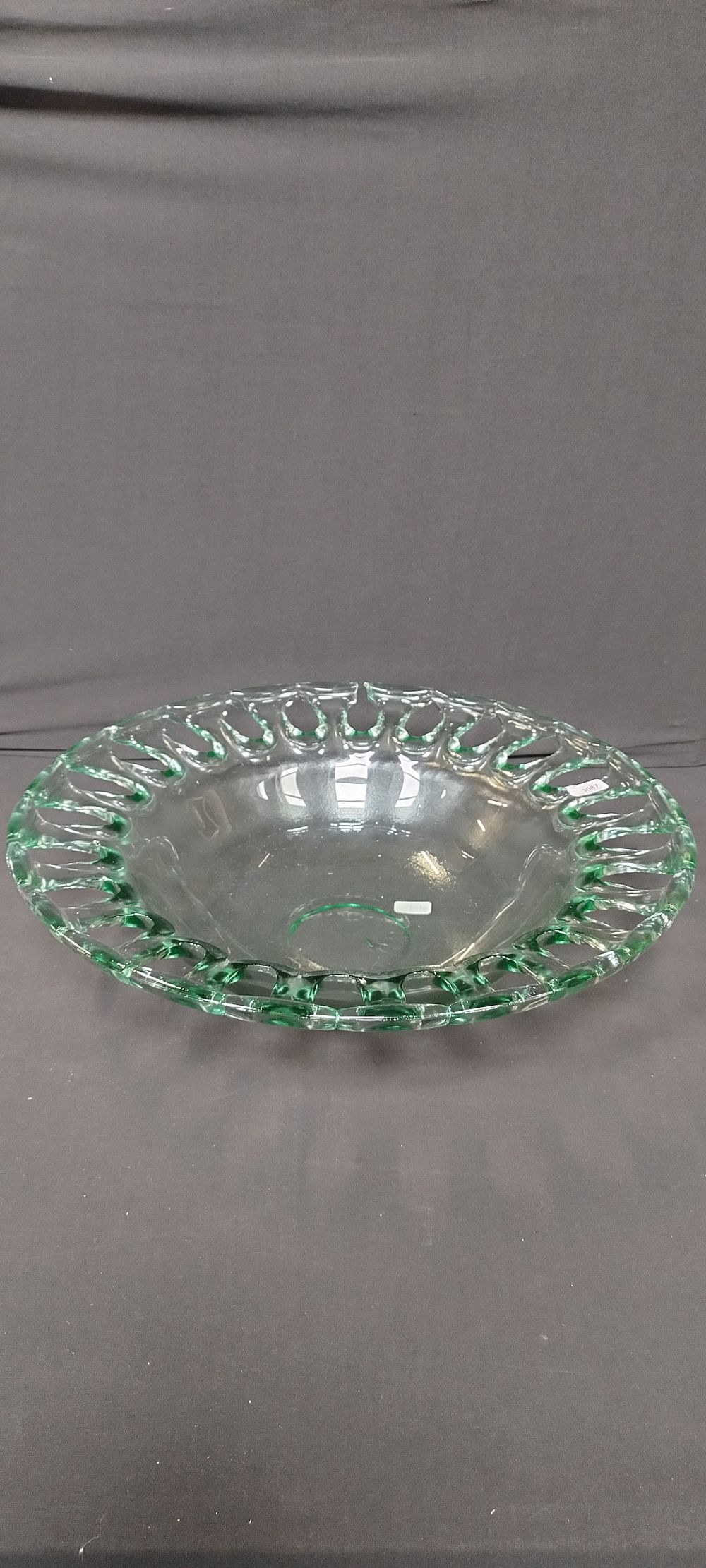 Lot 136: Large glass green bowl with decorative edging. Measures...