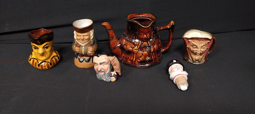 Lot 224: Collection of character jugs, a double faced teapot,...