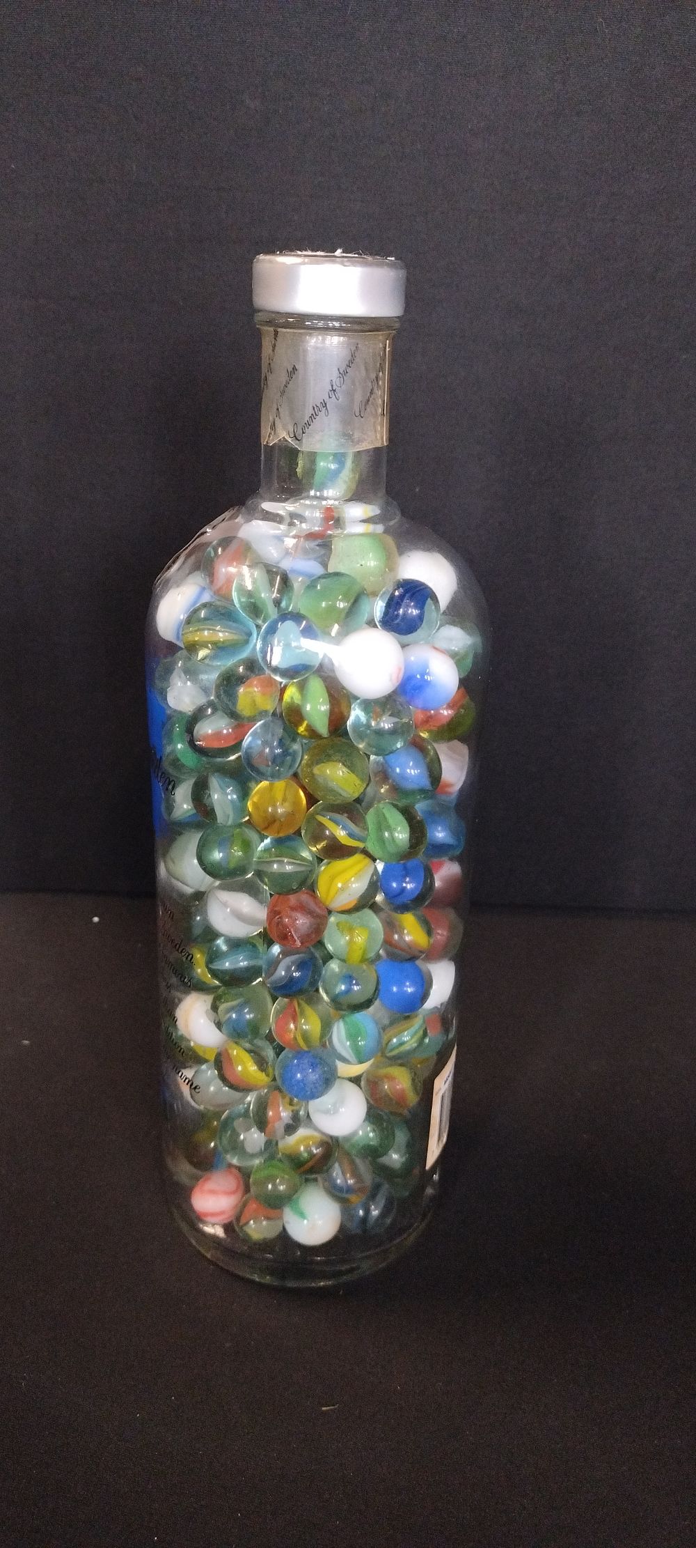 Lot 103: 1 ltr bottle filled with various marbles
