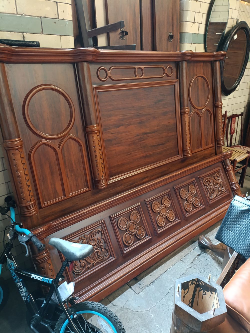 Lot 323: Large custom made wooden bed with ornate detailing....