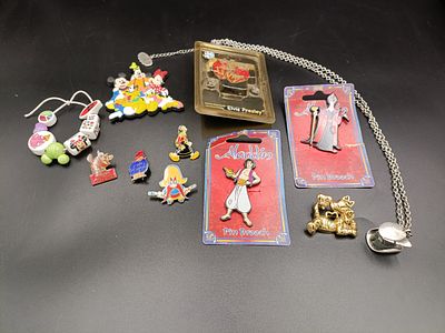 Selection of mostly vintage Disney badges, pins, magnets and necklace. Including Aladdin 