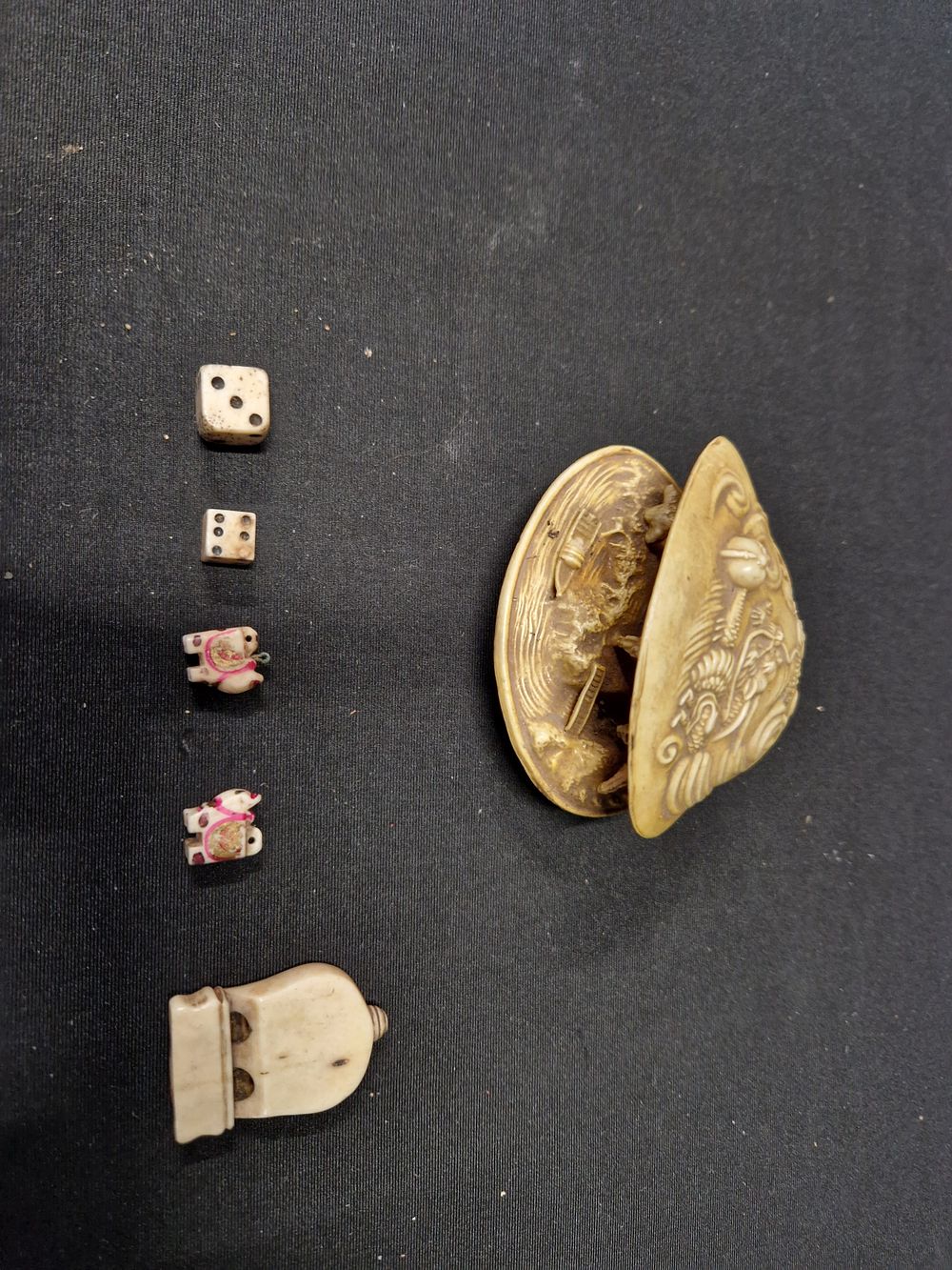 Lot 242: Antique bone dice and cat pendants along with...