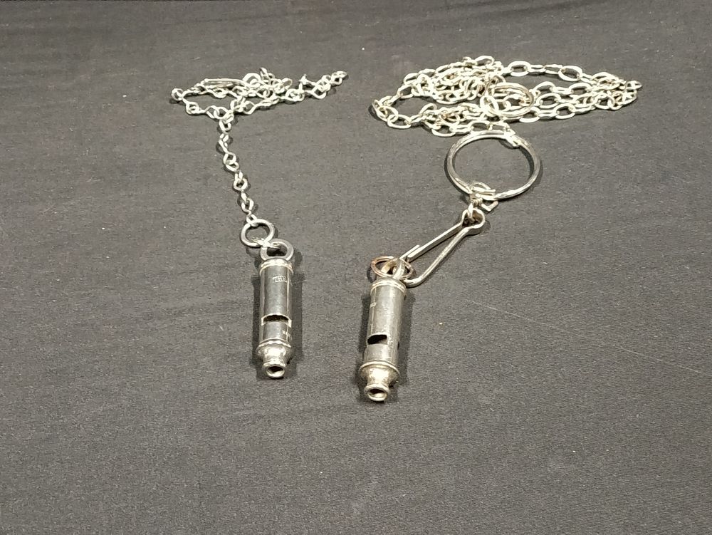 Lot 335: Two vintage metropolitan police/prison guard whistles on chains