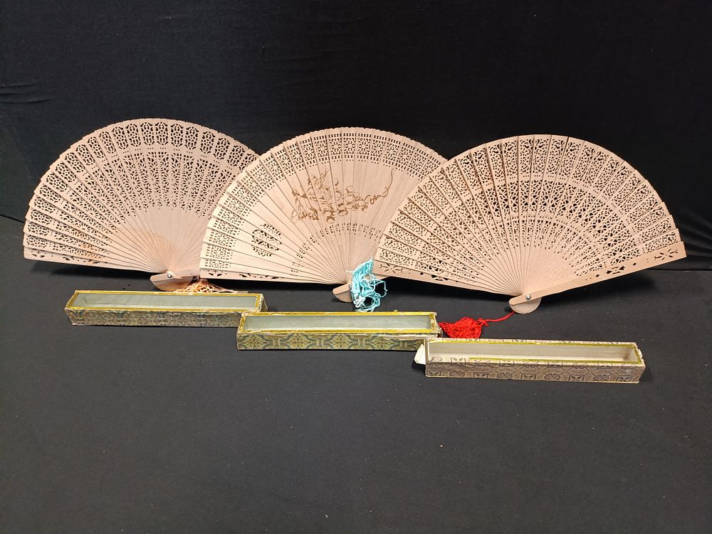 Lot 390: Three vintage wooden fans with intricate carved detailing...