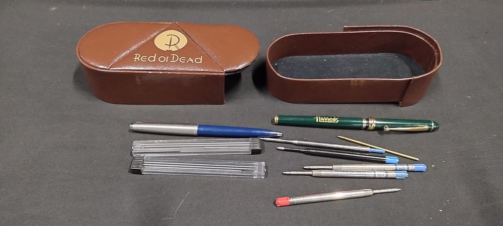 Lot 479: Red or Dead glasses case containing pens, refills,...