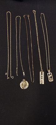 A selection of six gold plated chains and pendants