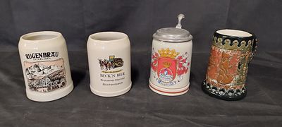 Four beer steins with various designs