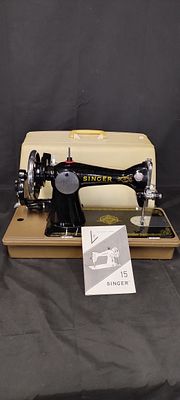 Vintage portable Singer sewing machine with lid and instruction booklet