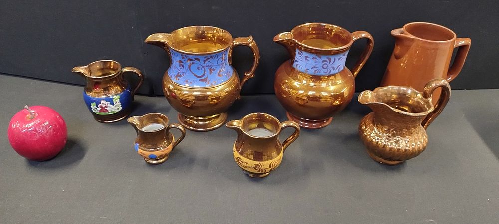 Lot 286: Selection of copper luster ware blue stripe jugs...