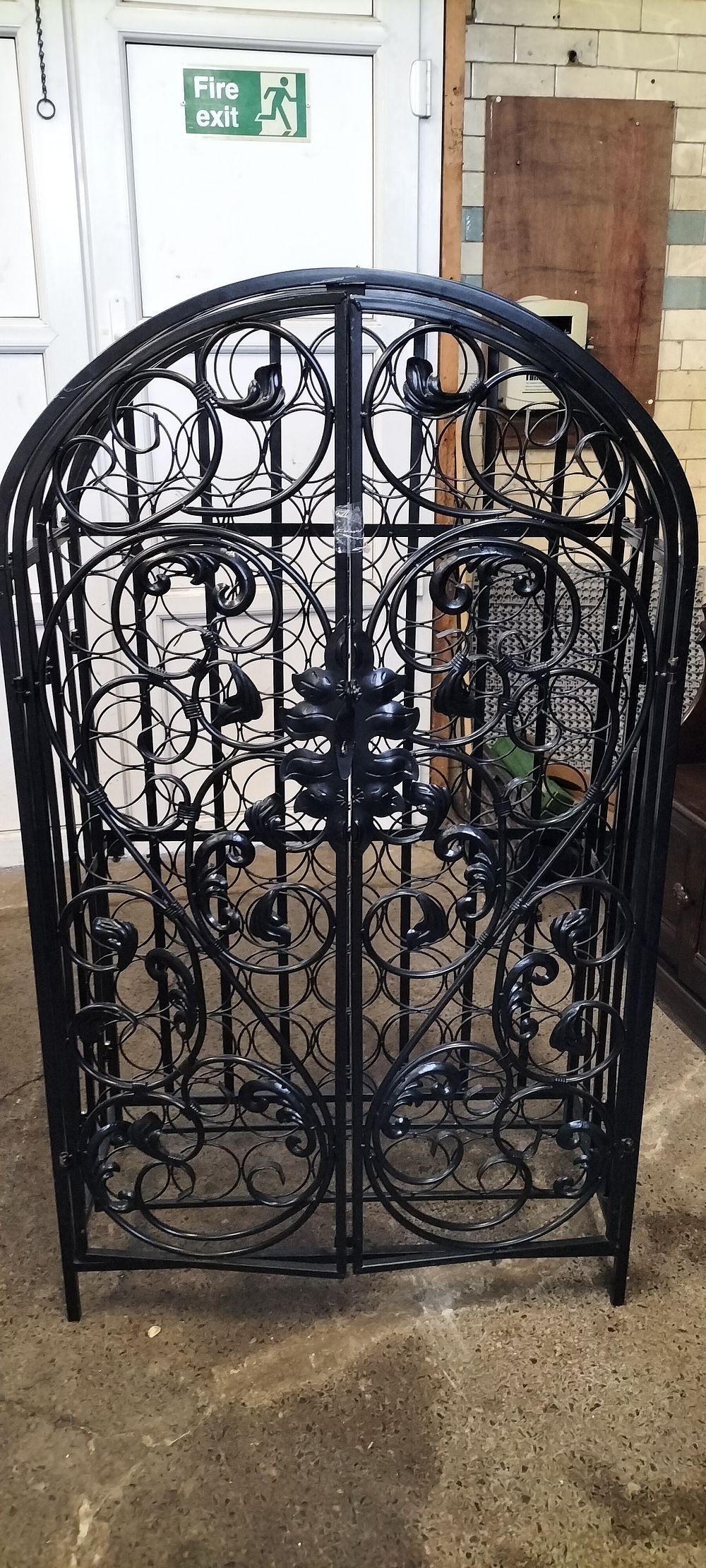 Lot 222: Ornate Black metal gated 79 hole bottle rack....