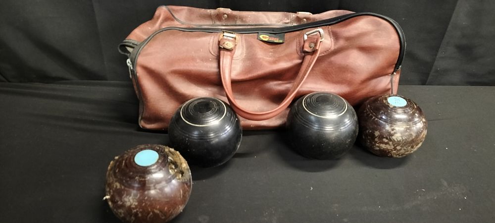 Lot 227: Four lawn bowls and bag