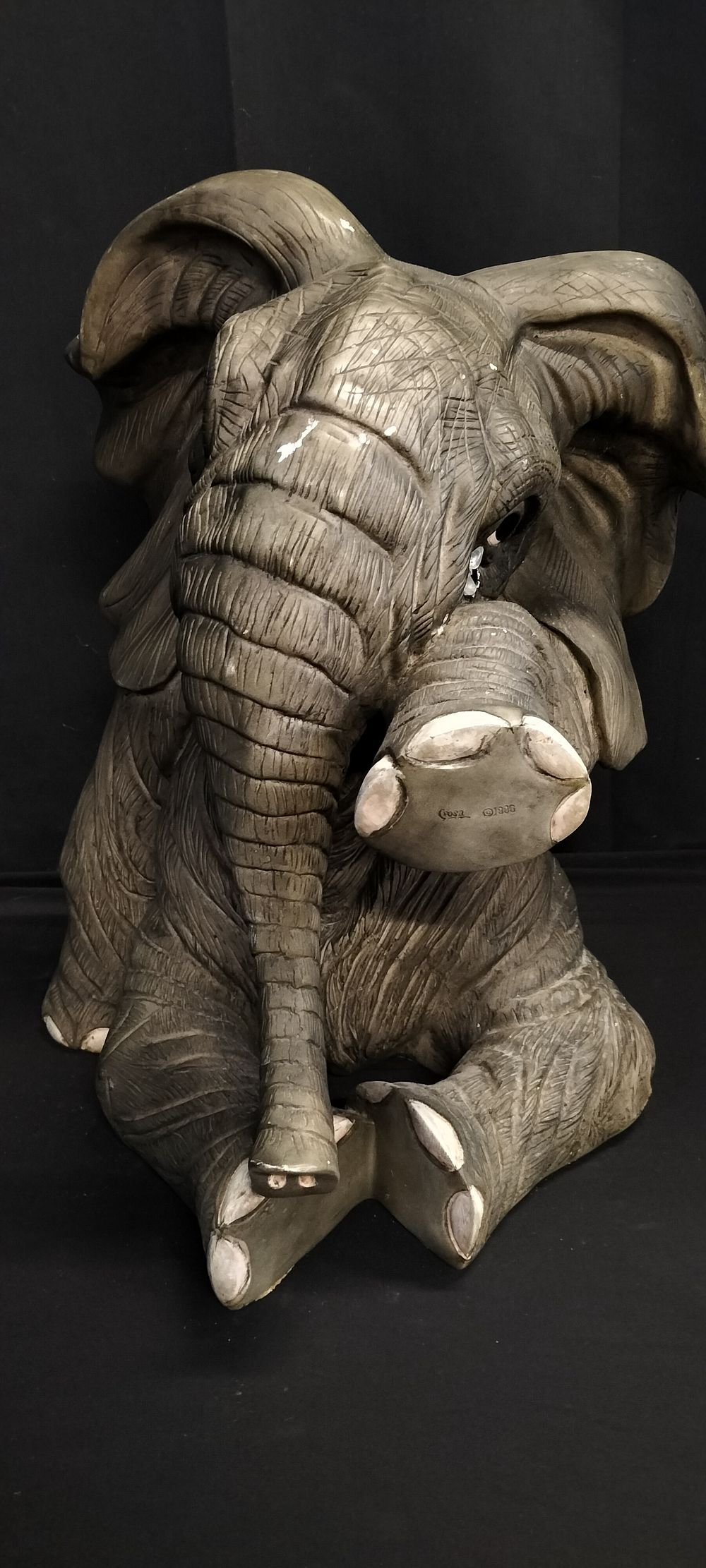 Lot 300: Statue of a sitting elephant wiping a tear....
