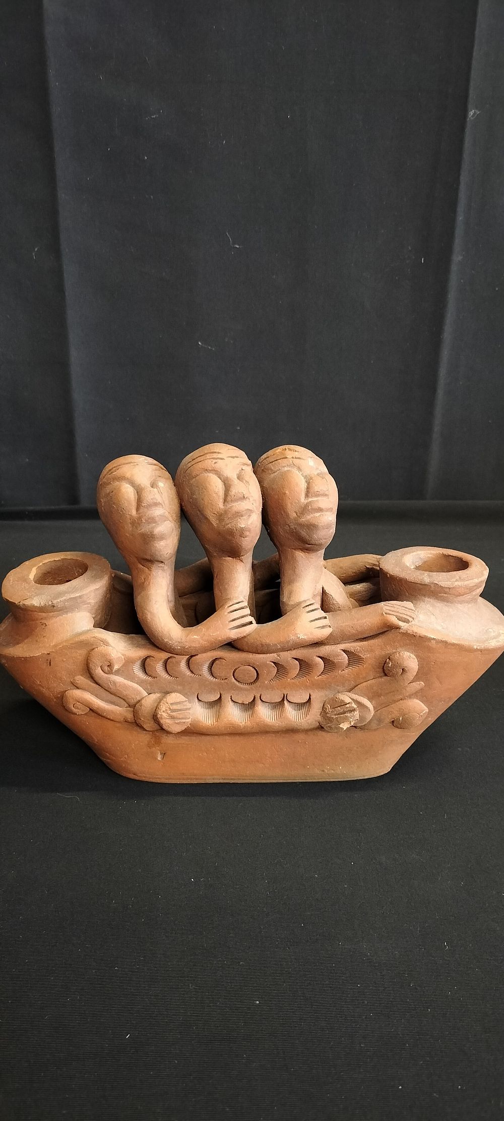 Lot 276: Terracotta candle holder depicting 3 African figures, seated...