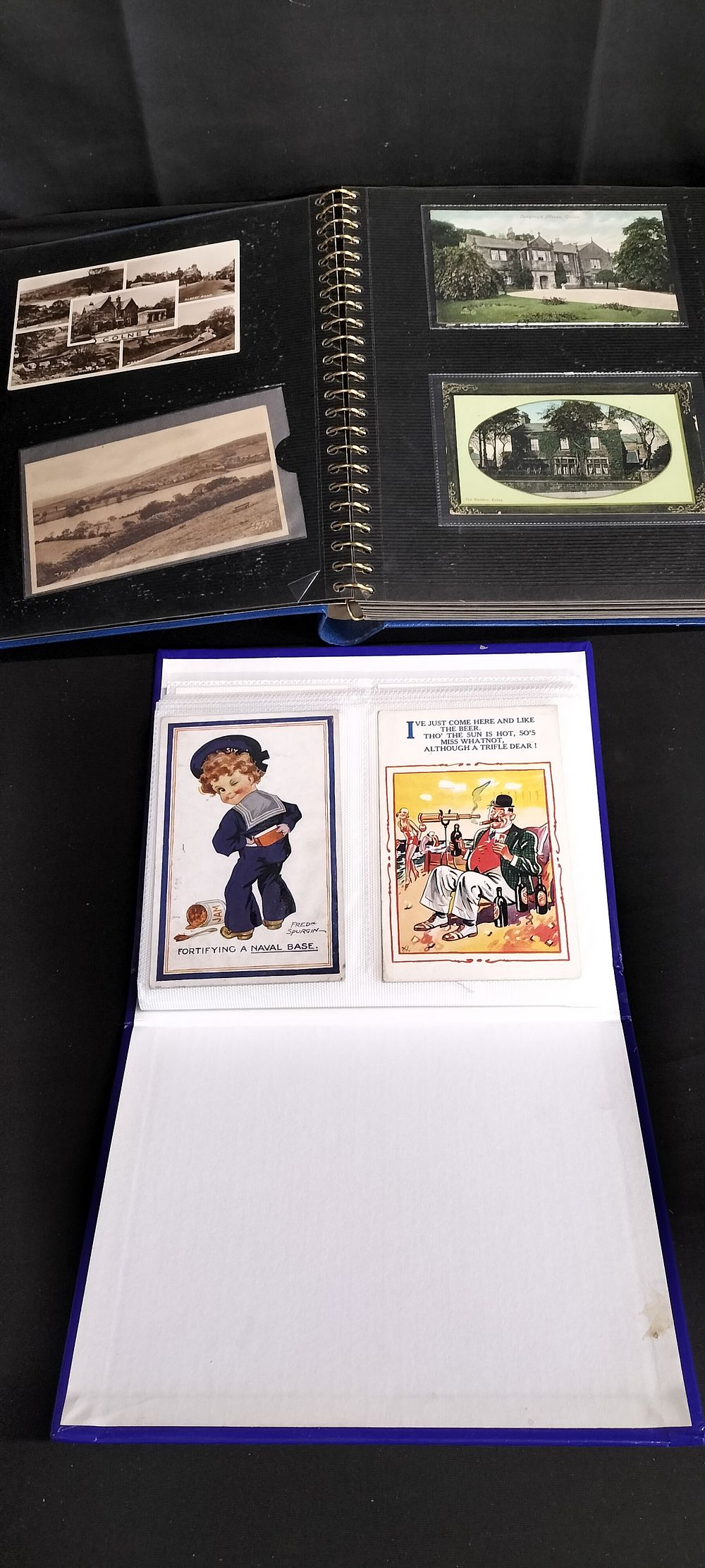 Lot 293: Two photograph albums containing vintage postcards from various...
