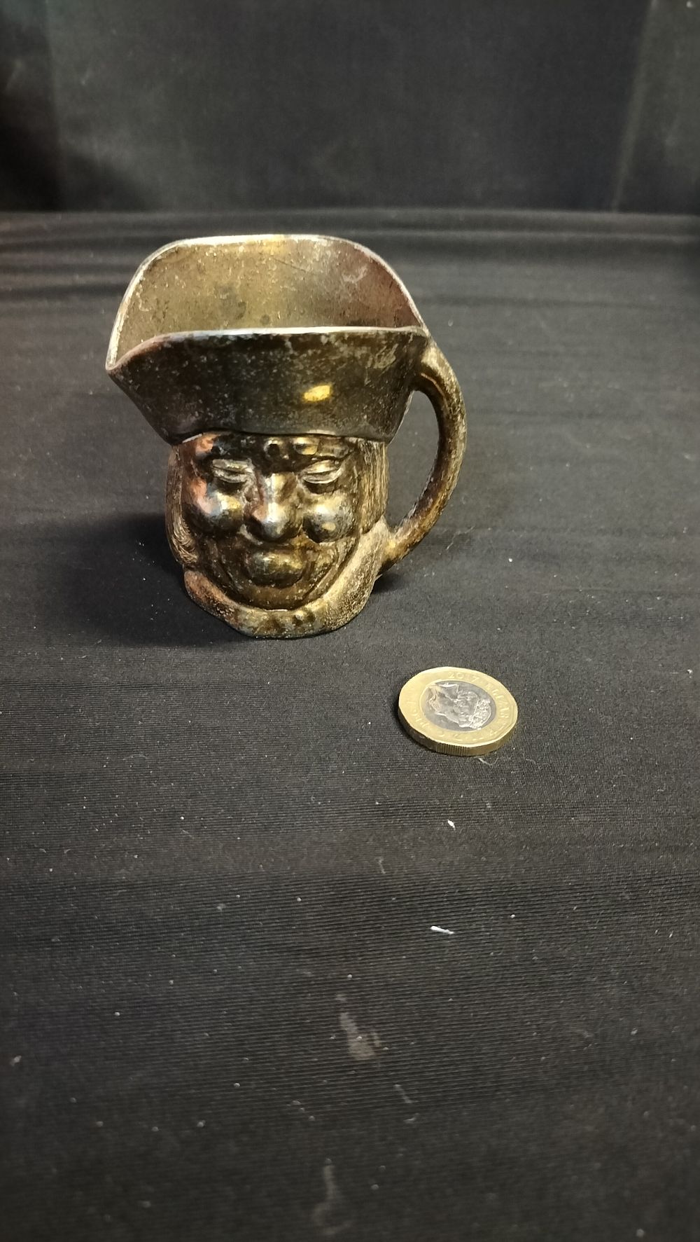 Lot 577: Small brass character jug