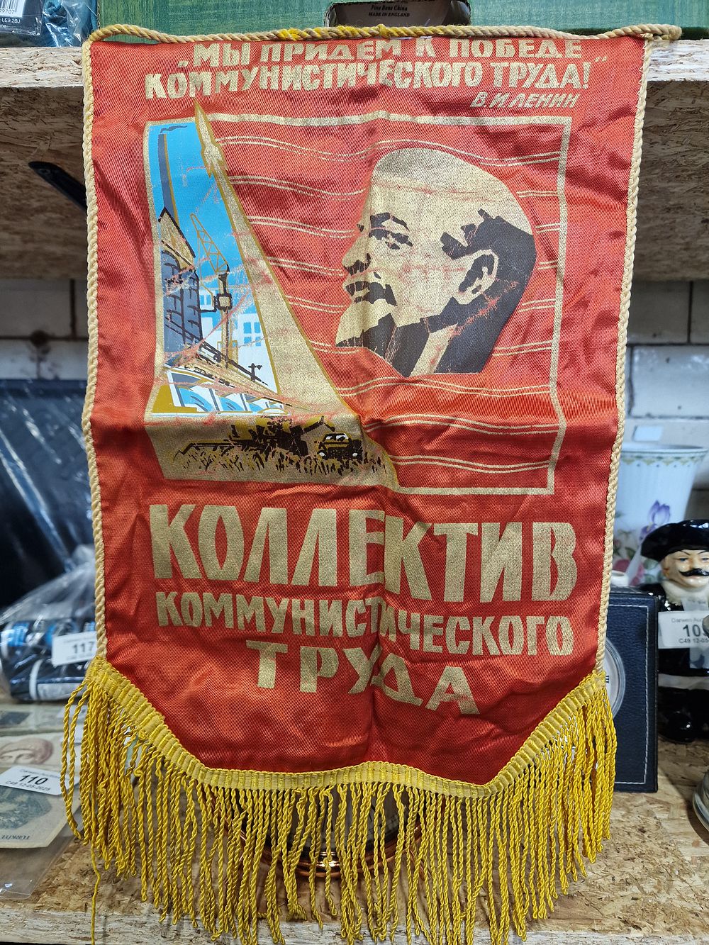 Lot 153: Vintage 1970s Soviet Pennant Banner Promoting the "Collective of Communist Labor." It features a quote from Vladimir Lenin: "We will come to the victory of communist labor!". Approx 45x26cm