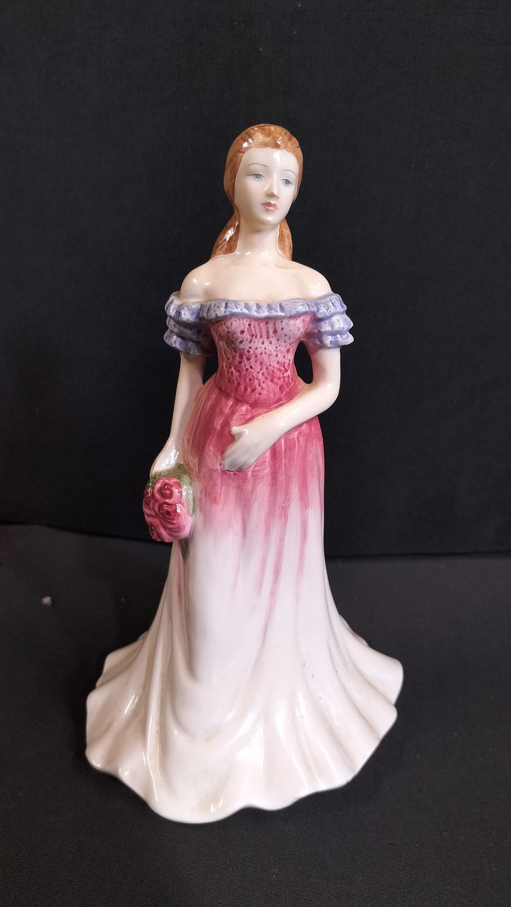 Lot 235: Porcelain figurine of a woman with flowers 