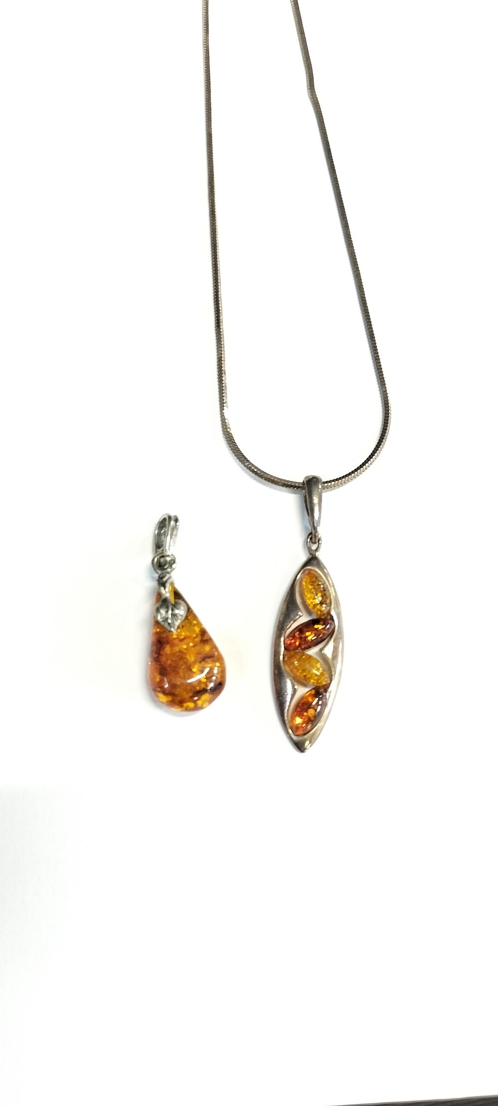 Lot 155: Two Amber Pendants One On a Sterling Silver...