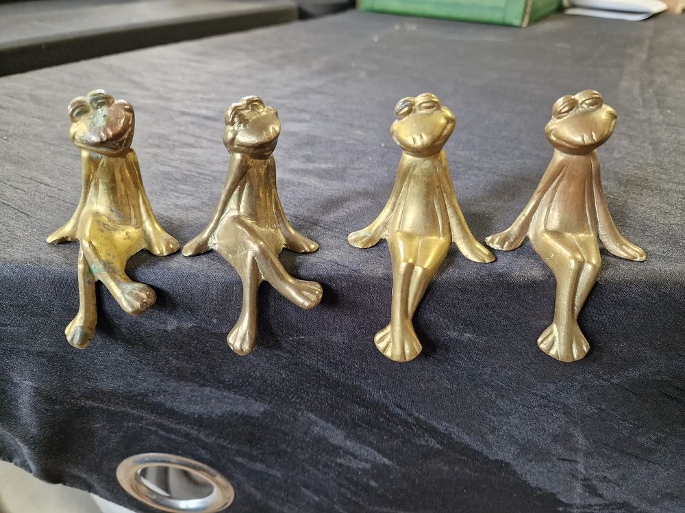 Lot 615: Four Brass Sitting Frogs for a Shelf