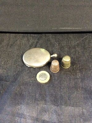 Vintage white metal locket 6cm in length and 2 thimbles. Thimbles
One is brass and the other
