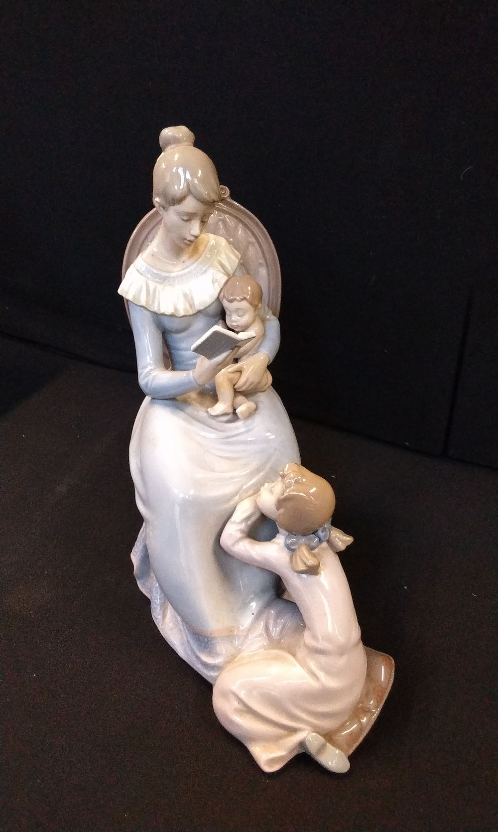 A large Lladro Figurine of Mother Reading. Measures Approx 25.5 x 12.5 x 23 cm