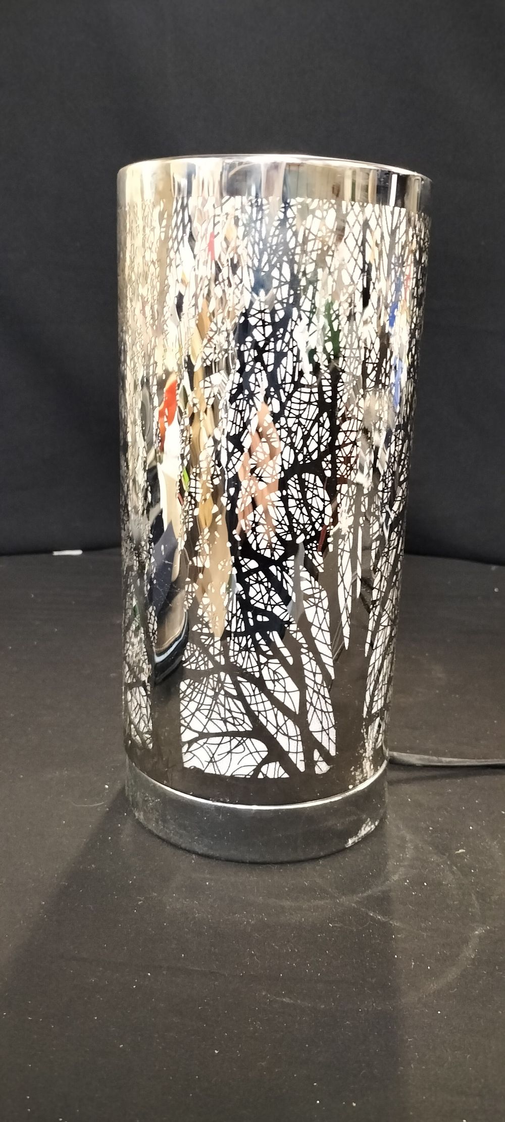 Lot 216: ** Silver-Colored Electric Tree Silhouette Lamp or Wax Warmer
**Detailed Description:** A silver-colored electric lamp or wax warmer features a black tree silhouette design, an internal light bulb, and an inline power switch.
**Condition Report:** Good
**