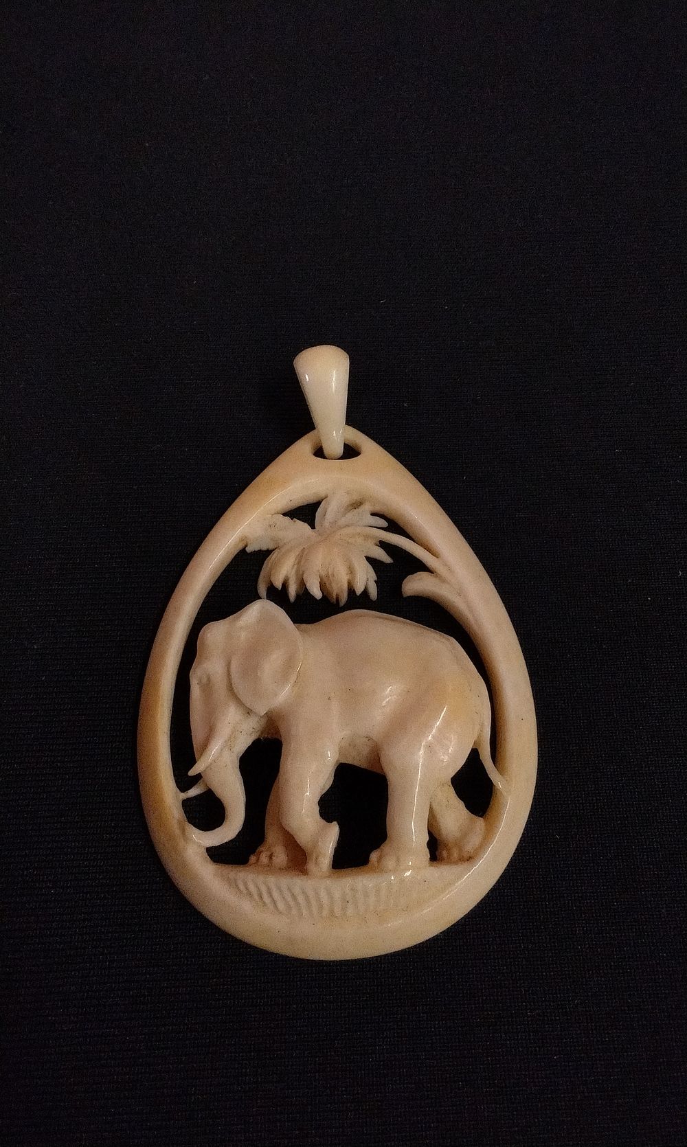 Lot 317: A Carved Creamy-White Elephant and Palm Tree Pendant