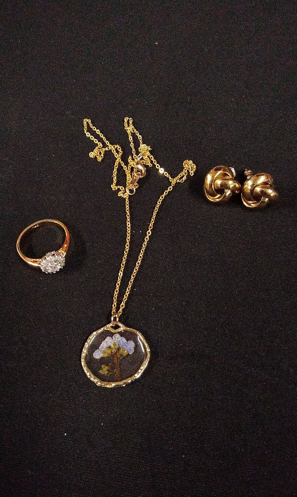 Lot 339: Gold-Toned Ring, Pressed Flower Necklace, and Knot Earrings