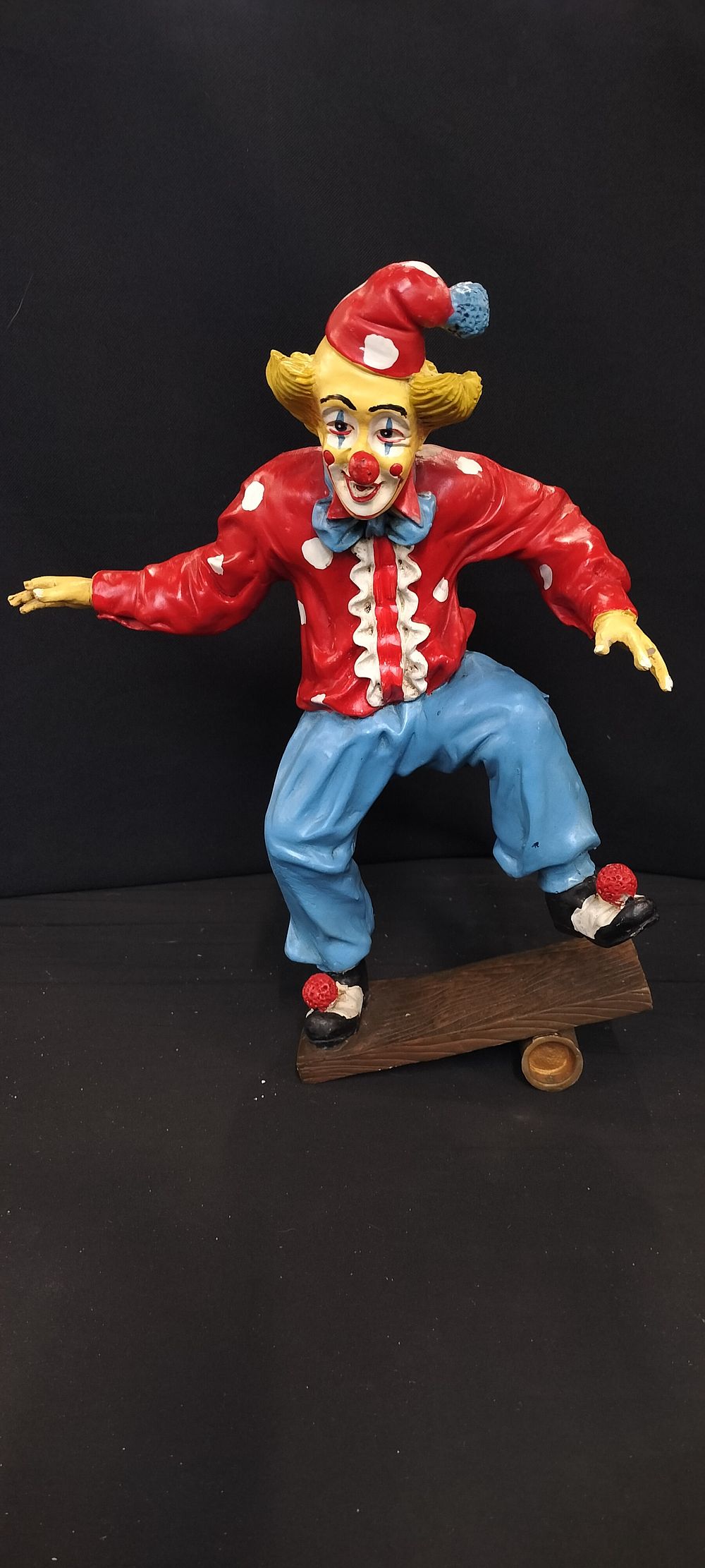 Lot 280: A Multicolored Clown Figure Balancing on Board