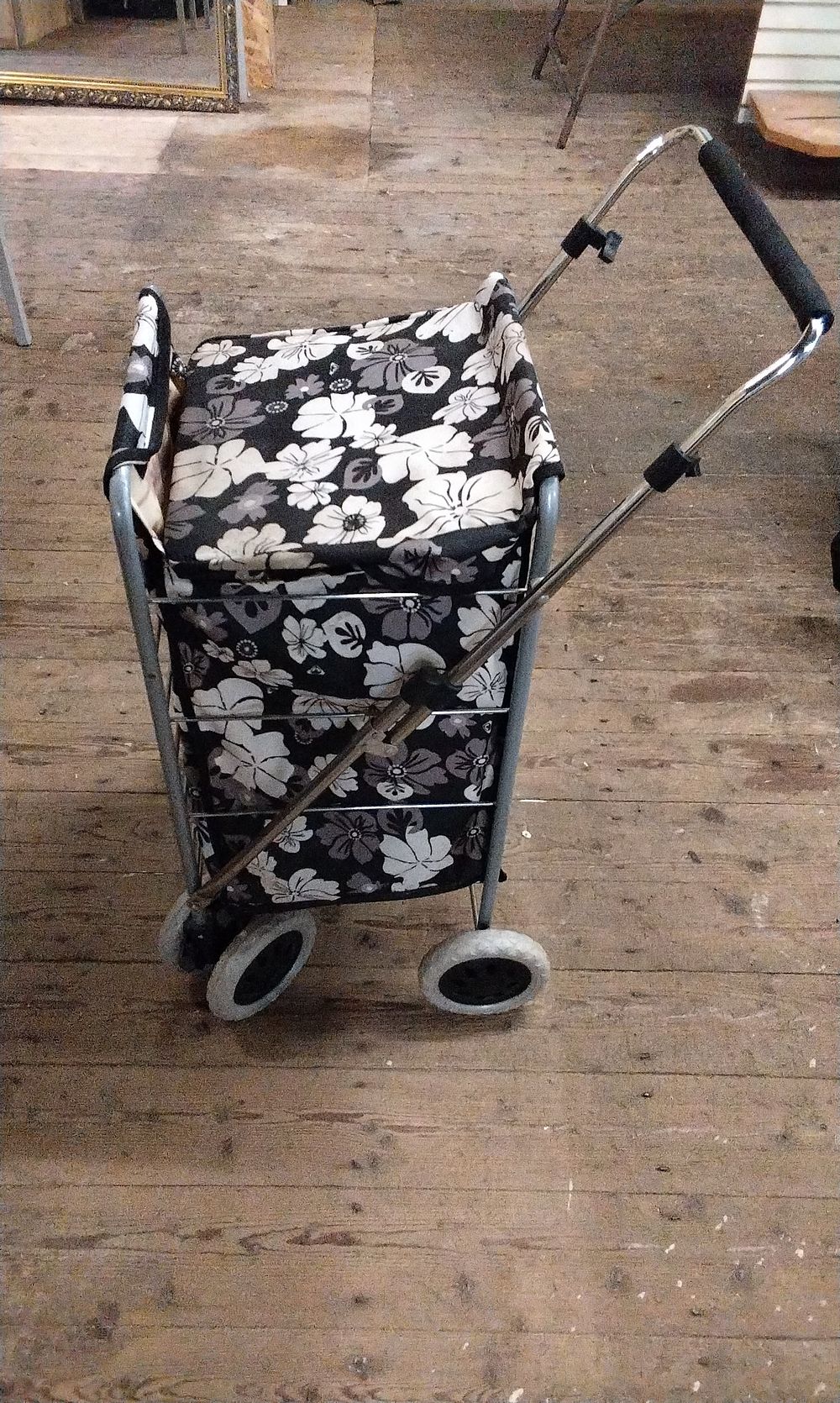 Lot 389: A Modern 6 Wheel Swivel Shopping Trolley with Black, White, and Grey Floral Print Bag. COLLECTION ONLY