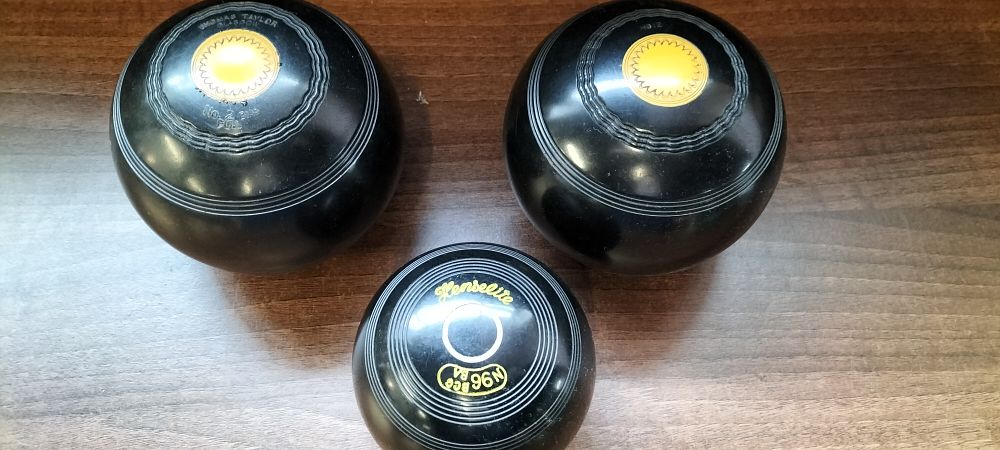 Lot 768: Three Black Lawn Bowls with Yellow Accents
