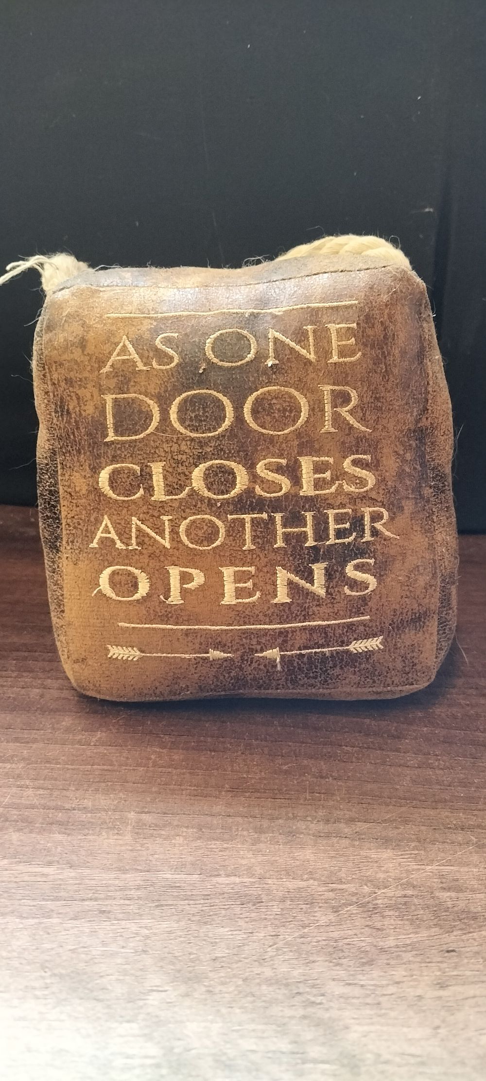 Lot 775: A Rustic Leather-Like Doorstop 'As One Door Closes'